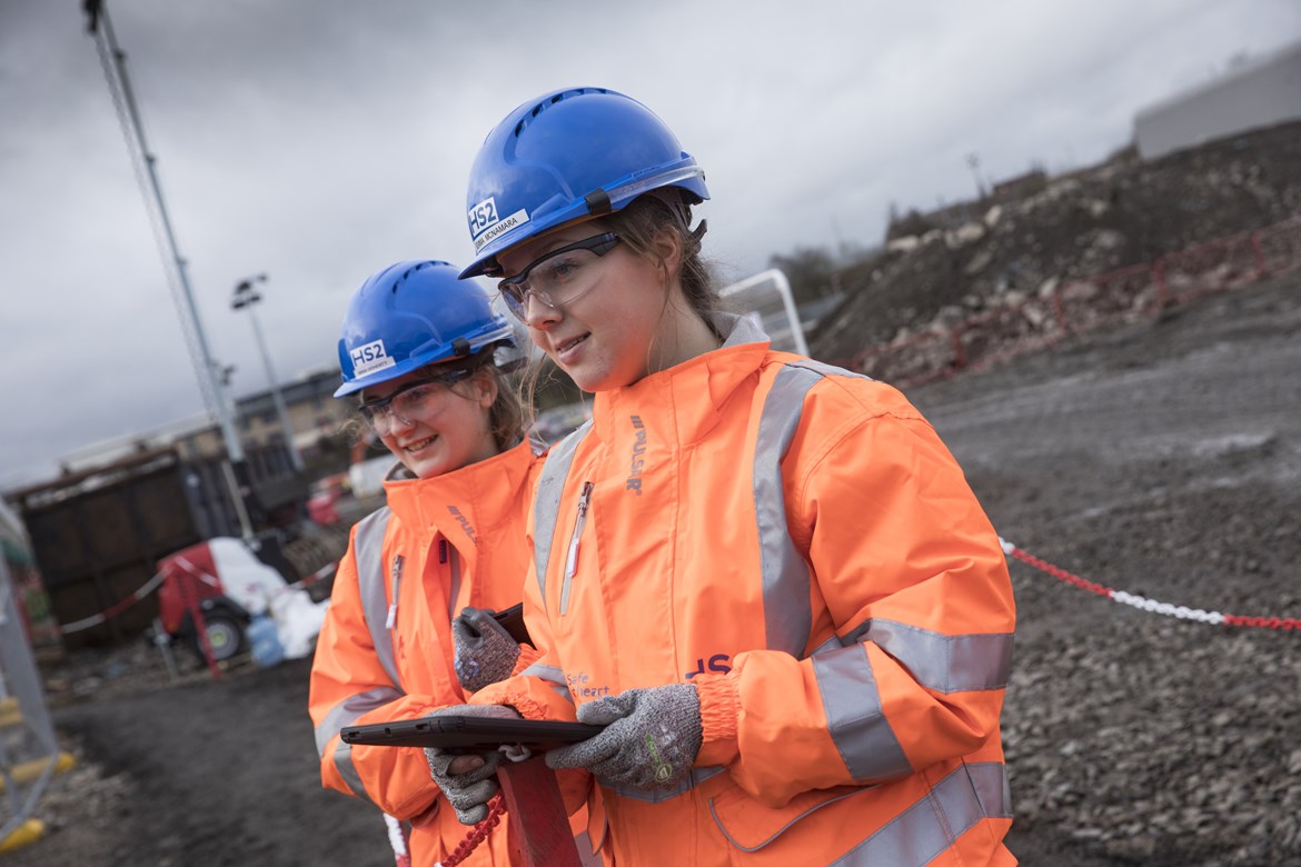 Graduate railway engineers in orange PPE